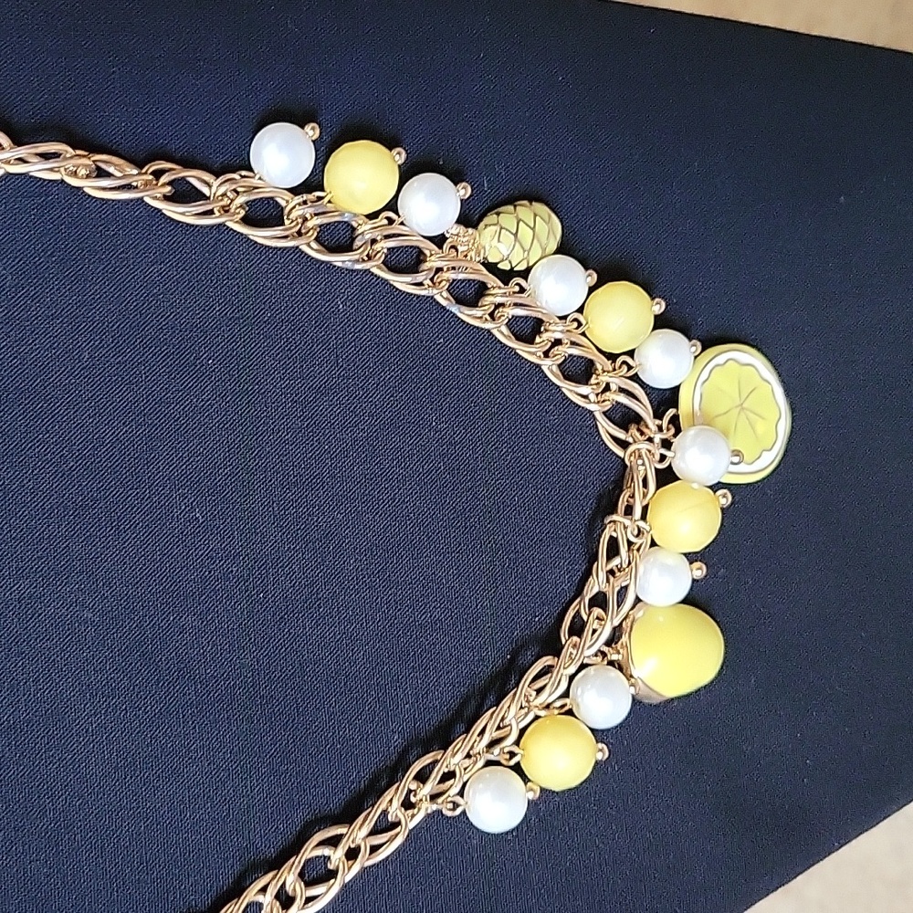 Charming Charlie goldtone necklace with yellow charms and white pearls.